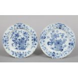 Two 18th century English delft blue and white plates painted with flowers, 22cm diameter.