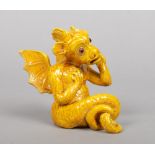 A Burmantofts Faience grotesque model of a winged gargoyle. Decorated in yellow glaze and with glass