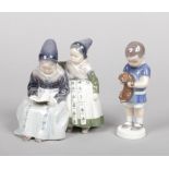 Two Royal Copenhagen figures. One formed as a pair of children reading from a book and the other a