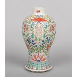 A 19th century Chinese baluster shaped vase. Painted in coloured enamels with lotus scrolls, fruit