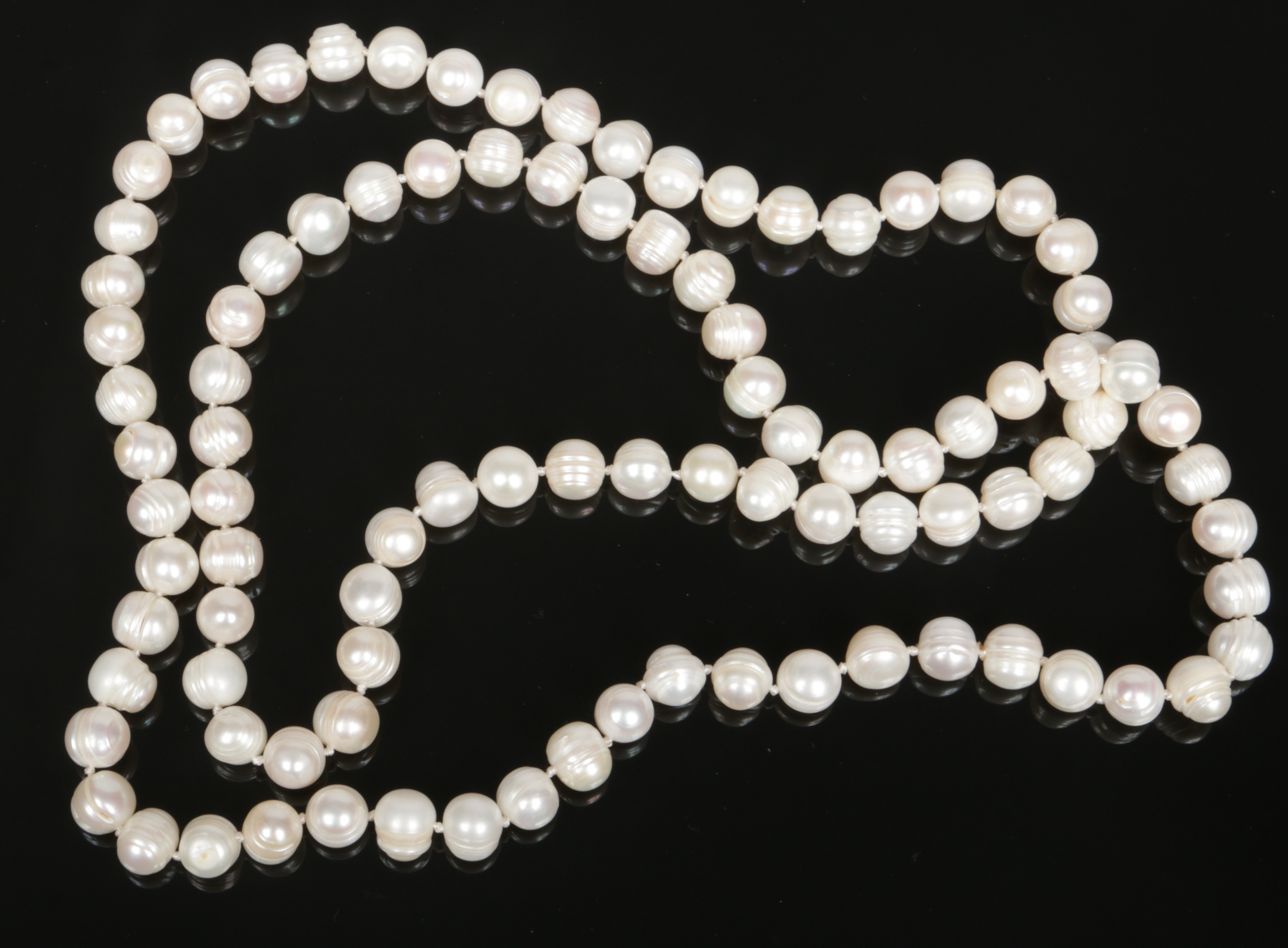 A long string of Baroque freshwater pearls each of natural ribbed form. 112cm total length, pearls
