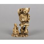 A Japanese Meiji period carved ivory okimono. Formed as a man carrying and being choked by an