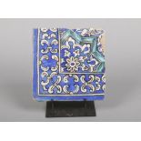 An antique Turkish Iznik style corner tile on stand. Glazed in tones of blue and turquoise, 21.