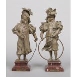 A pair of early 20th century French verdigris spelter figures on antico rosso marble plinths. Jeux