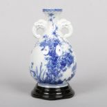 A Japanese blue and white bottle vase. With twin mask handles and painted in underglaze blue with