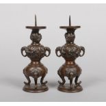 A pair of Japanese Meiji period bronze candle prickets. Decorated in relief with a dragon, birds and