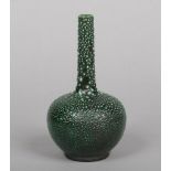 A Burmantofts Faience bottle vase. Moulded with shagreen texture and glazed in mottled green.