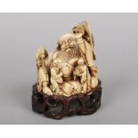 A 19th century Chinese large ivory carved group on pierced hardwood plinth. Formed as a seated