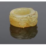 A Chinese jade coloured hardstone archers ring. Carved around its circumference with a mythical