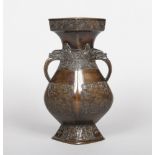 A Chinese archaistic bronze twin handled vase. Decorated in relief with fretwork panels, 27cm.