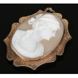 A 9 carat gold mounted carved shell cameo brooch. Depicting the profile portrait of a Grecian woman,