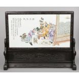 A large Chinese 20th century scholars screen. With carved hardwood stand and frame housing a