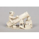 A Japanese Meiji period miniature ivory okimono. Formed as a pair of carpenters, one seated upon a