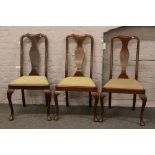Three mahogany dining chairs raised on cabriole supports.