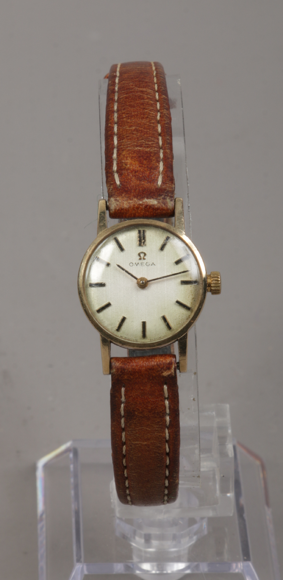 A ladies 9ct gold manual Omega wristwatch with satin dial and applied baton markers.