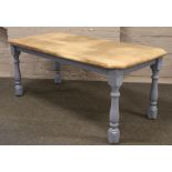 A part painted oak dining table with sanded top raised on turned supports.