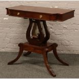 A mahogany reproduction Regency style side table raised over lyre supports.