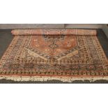 A pink ground wool rug with medallion design, 280cm x 188cm.