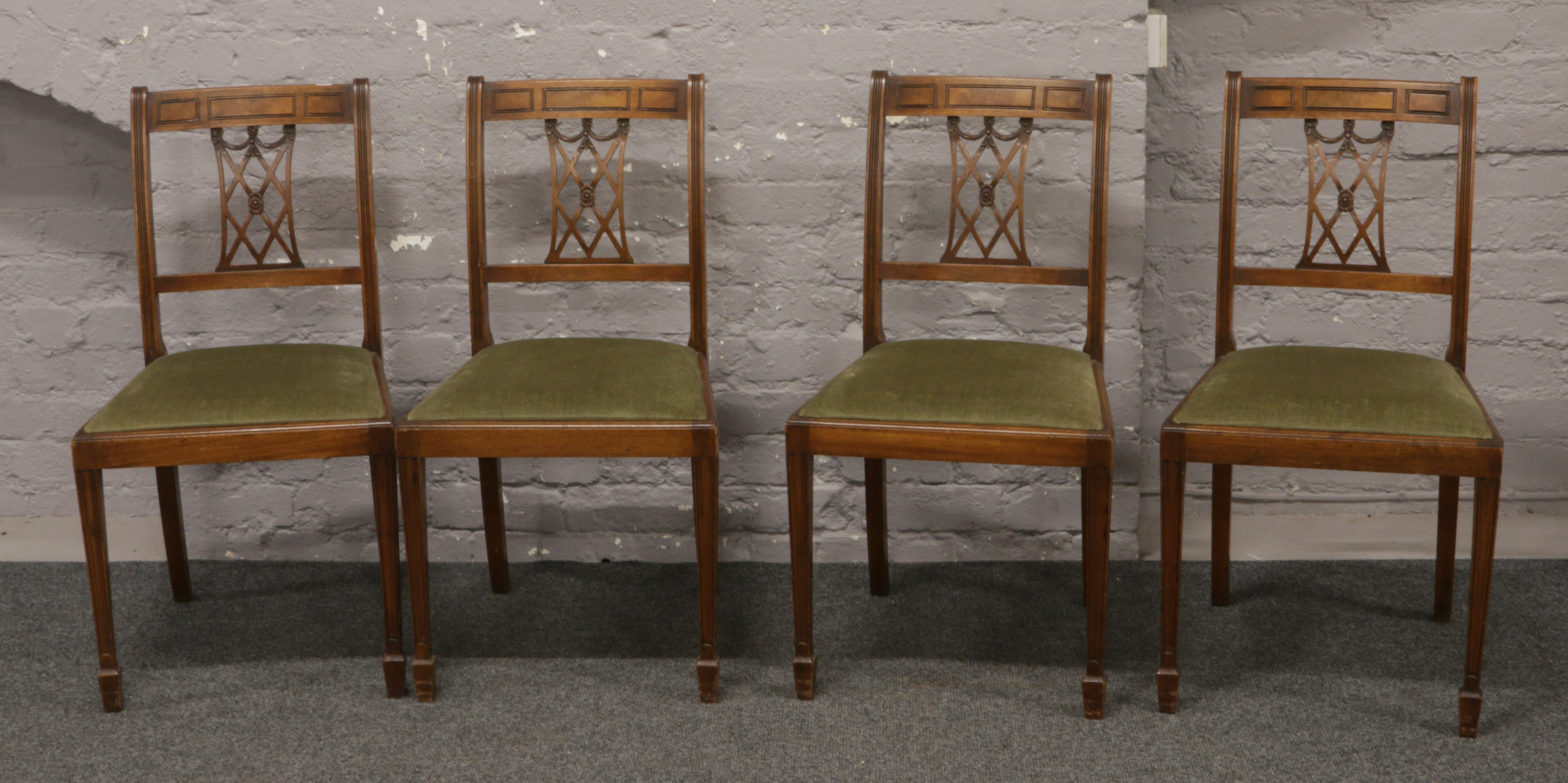 A set of four pierced back dining chairs.