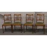 A set of four pierced back dining chairs.