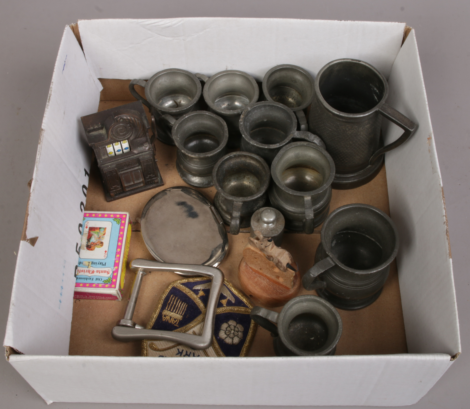 A box of antique pewter measures and collectables.