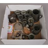 A box of antique pewter measures and collectables.