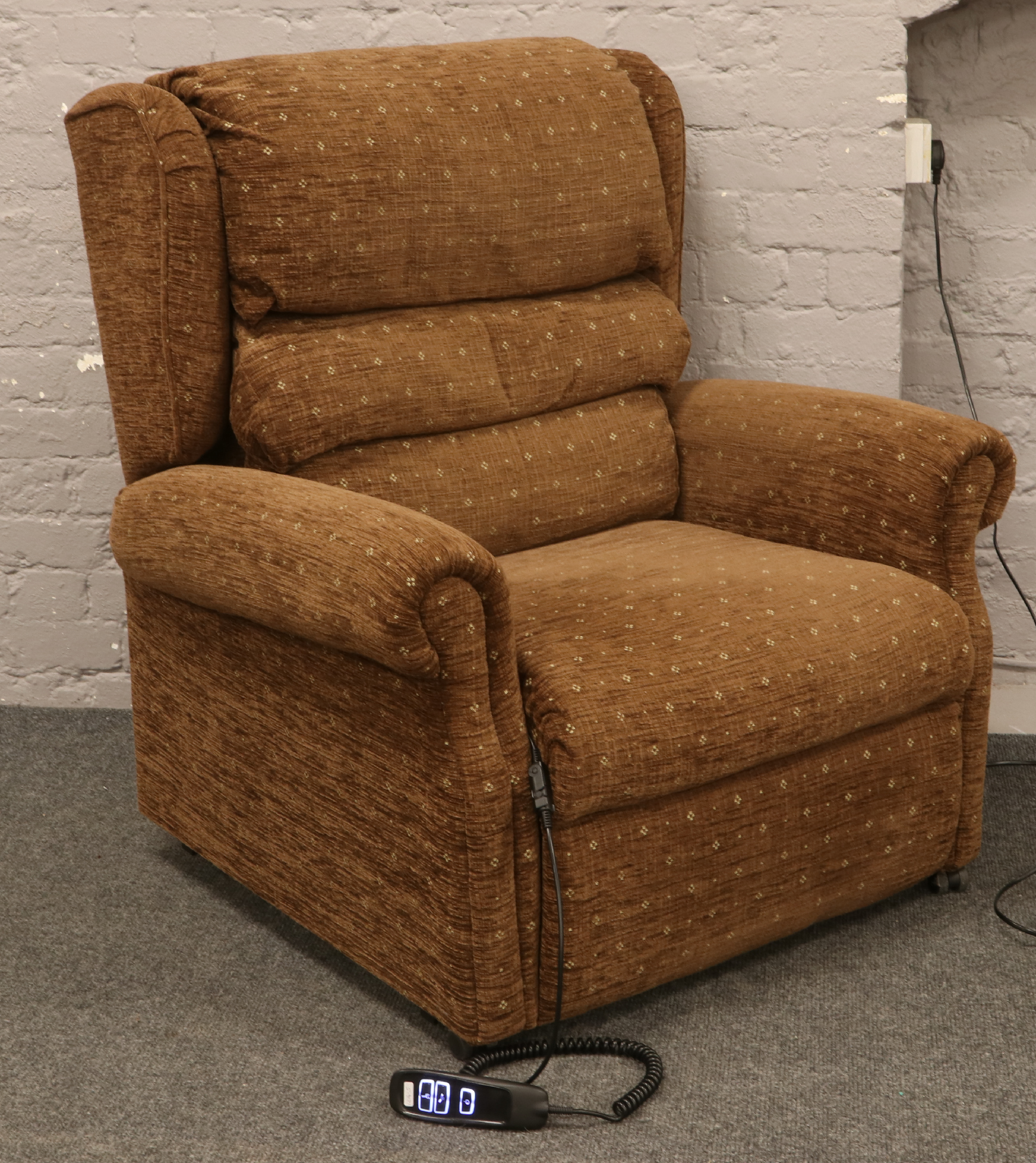 A brown upholstered Deltadrive DSI electric riser / recliner arm chair by Okin.