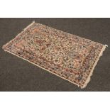 An ivory ground wool rug with all over floral design, 125cm x 77cm.