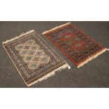 Two small wool rugs / prayer mats both with geometric designs, 87cm x 62cm.