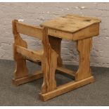 A Victorian pine school desk with attached chair.