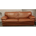 A tan coloured good quality leather three seat settee raised on bracket feet.