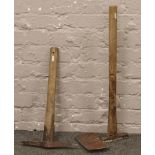 Two vintage mining related tools, a pick axe and another.