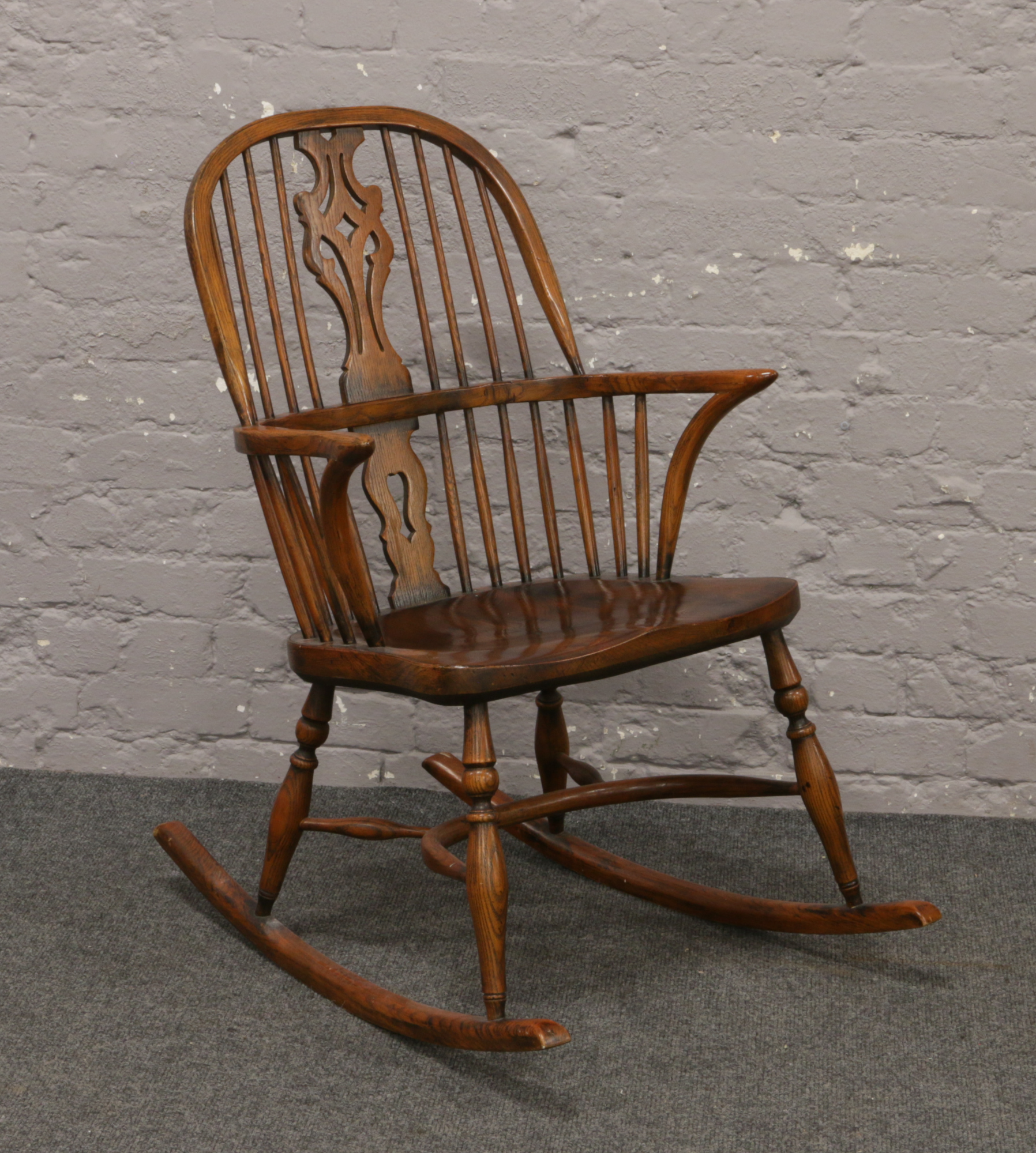 An ash and elm Windsor rocking arm chair with crinoline stretcher.
