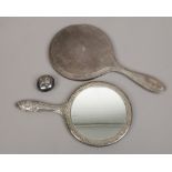 A silver dressing table mirror, along with a white metal example and a silver babies rattle head.