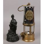 An Eccles type 6 miners re-lightable protector lamp along with a carved coal figure of a miner.