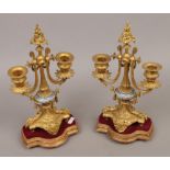 A pair of French ormolu twin branch candelabra with Sevres style knops and raised on giltwood