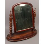 A Victorian mahogany toilet mirror with bobbin turned supports.