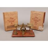 A set of vintage brass postal scales on oak plinth with weights along with two empty Moulton cadet