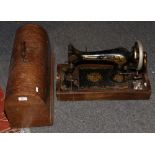 A cased Singer sewing machine, model number J207627 with ornate gilt decoration.