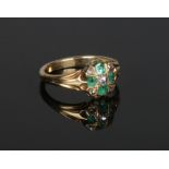 A Victorian gold emerald and diamond cluster ring with reeded shoulders. 3.58 grams, size L.