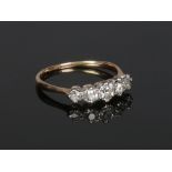 A gold five stone diamond ring. Set with a line of five graduated old European cut diamonds,