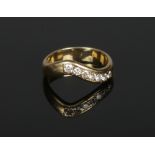 An 18 carat gold wishbone ring channel set with seven diamonds. Approximately 0.35ct total weight,