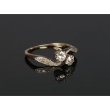 A gold diamond crossover ring. Set with two round cut diamonds approximately 0.2ct each and with