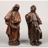 A pair of early 19th century Continental carved wooden statues formed as Saints dressed in flowing