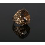 A 9 carat gold smokey quartz cocktail ring with scrolling openwork shoulders. Size F.