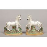 A pair of 19th century Staffordshire models of zebra. Each raised on a naturalistic base