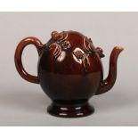 A Brameld treacle glazed Cadogan pedestal teapot. Moulded with leaves and berries. Impressed mark