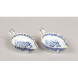 A pair of 18th century Chinese export fluted blue and white sauceboats. With scrolling loop