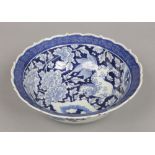 A Chinese blue and white bowl with scalloped rim. Painted in underglaze blue with a kylin in a