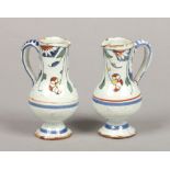 A pair of small 19th century Continental polychrome delft ewers painted with flowers, 10.75cm.